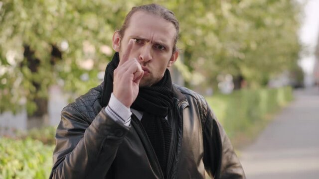 Portrait man shaking index finger toward the camera several times means prohibition. Finger wag.