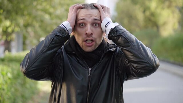 Portrait of emotionally shocked man screaming in fear and scare outdoors. Cry of fear. Facial expression. Concept of people and emotions.