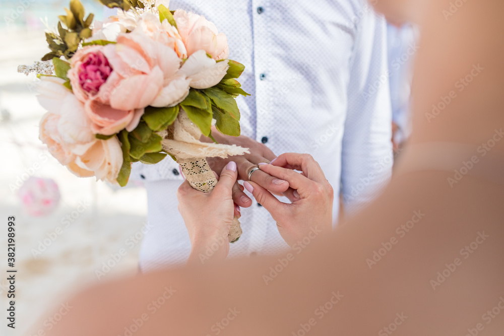 Wall mural Close up view of ring exchange at the wedding ceremony on the paradise beach, Punta Cana, Dominican Republic 