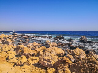 Fototapeta na wymiar Crystal clear azure water with white beach, stones and palms - paradise coastline coastline of Hurghada, Red Sea, Egypt