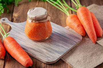 Canned carrot sauce salad with garlic and horseradish in a jar with fresh vegetables, recipe...