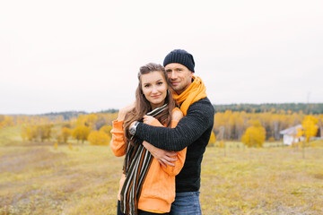 A young couple in love hug and walk in the Park on a Sunny autumn day
