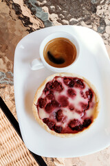 Morning the cafe, cup of espresso and berry dessert.