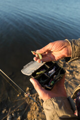 Fisherman puts on silicone bait. Jig fishing, Silicone gear.
