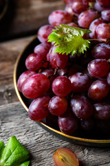 Pink grape on wooden table on wooden background. Vine grape. Still life of food.