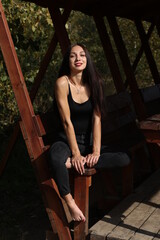 Fototapeta na wymiar young brunette sitting in a wooden gazebo