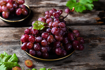Pink grape on wooden table on wooden background. Vine grape. Still life of food.