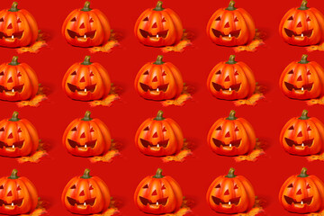 Pattern. There are a lot of pumpkins with a carved smile on a red background. Pumpkins standing in glad. Halloween celebration concept.