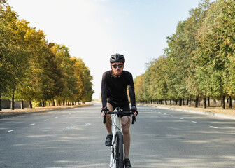 Portrait of a man on a gravel bike on the road. Well equipped cyclist riding a modern bicycle outdoors