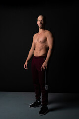 Naklejka premium Serious Russian guy pumped sports Caucasian stands on a black background