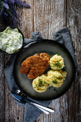 Pork chop served with mashed potatoes and cucumber salad.