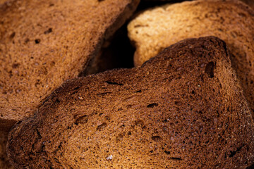 The texture of toasted pieces of bread. Croutons on a white background. Dark dry bread.
