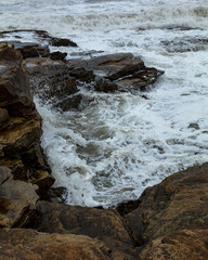 Rough, stormy, seas and waves on rock at Seaton Sluice, Northumberland, England, UK.