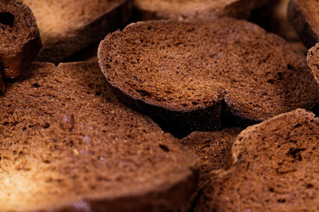 The texture of toasted pieces of bread. Croutons on a white background. Dark dry bread.