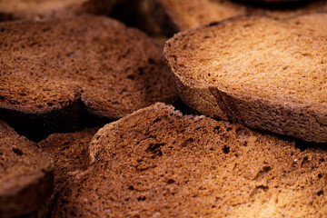 The texture of toasted pieces of bread. Croutons on a white background. Dark dry bread.