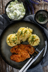 Pork chop served with mashed potatoes and cucumber salad.