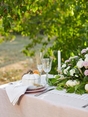 Table setting with beautiful autumn decorand with white mini pumpkins and crystal glasses for Thanksgiving Day or Halloween