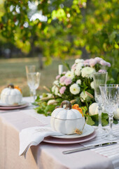 Table setting with beautiful autumn decorand with white mini pumpkins and crystal glasses for Thanksgiving Day or Halloween