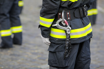 Details with the carabiner and harness of a firefighter.