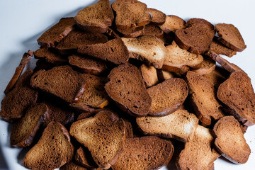 The texture of toasted pieces of bread. Croutons on a white background. Dark dry bread.