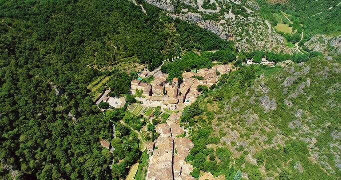 Aerial view over Saint Guilhem Le D&eacute;sert a beautiful traditional village in France in the middle of mountains 4K drone view 
