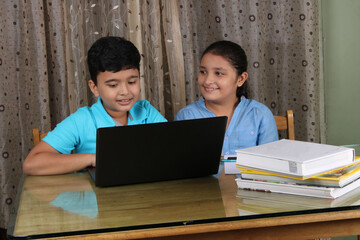 Education at home concept - 2 Cute Indian/Asian kids studying/doing homework.