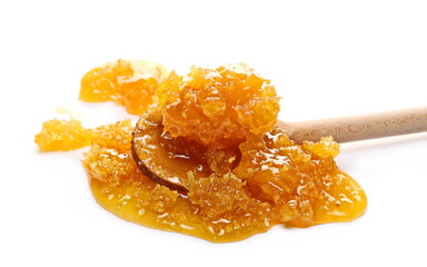 Honey in honeycomb with wooden spoon isolated on white background