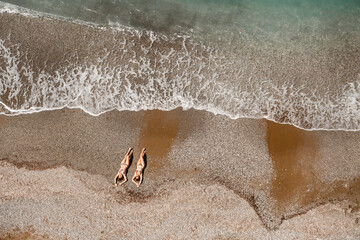 An empty asphalt road winds along the breathtaking scenic coastline on a sunny summer day. A spectacular shot of a coastal road overlooking clear blue skies and the calm Mediterranean Sea.