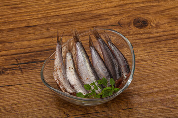 Anchovies in the bowl served basil leaves