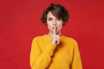 Secret young brunette woman 20s wearing casual yellow sweater standing saying hush be quiet with...