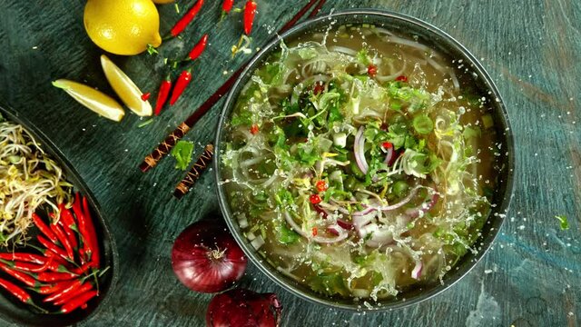 Super Slow Motion Shot of Ingredients Falling into Vegetable Pho Soup at 1000 fps.