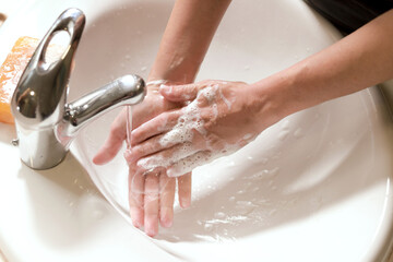 manos de mujer con espuma de jabón en un lavado como medida de precaución contra covid - obrazy, fototapety, plakaty