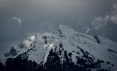 sommet enneigé avec bourrasque de vent d'une montagne dans les alpes en France à La Clusaz