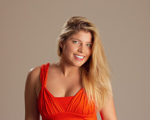 Portrait of beautiful happy smiling blonde woman. Open. Brazilian in neutral background. Responsive and welcoming.