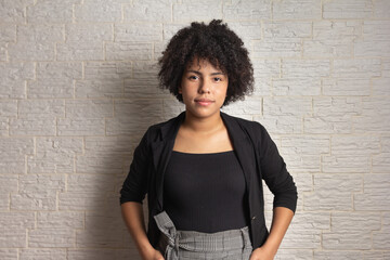 Portrait of Confident african american girl with curly hair. Isolated on white brick wall