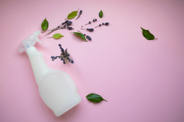 Plastic bottle with liquid for washing glass, plumbing, tiles or floor and lavender sprigs on a pink background with space for text. Natural organic cleaning product. Eco-concept. Poster.
