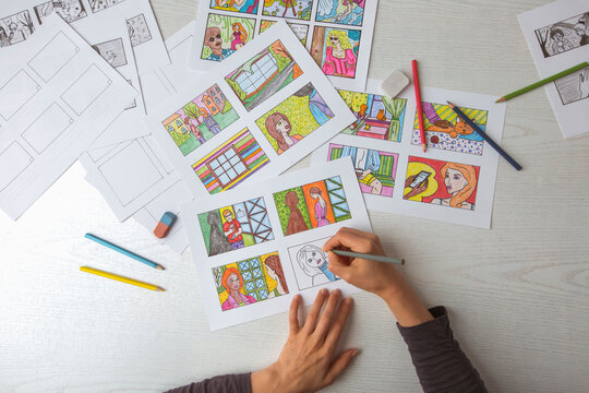 An animator painter draws a color storyboard for a comic book or movie. An illustrator seated at his desk creates a storyboard for a cartoon.