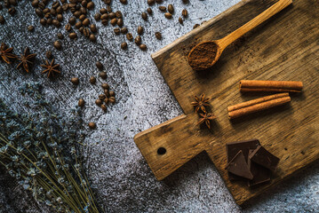 coffee, chocolate, cinnamon and spices on a brown wooden board 2