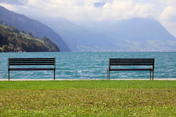Two empty benches on the lake shore