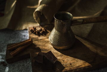 coffee, chocolate, cinnamon and spices on a brown wooden board