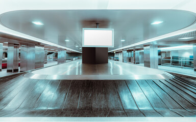 A frontal wide-angle view of a baggage claim area in a hall of an airport arrival zone with...