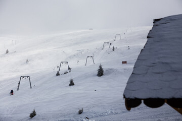 Sicht auf Skilift mit Haus im Vordergrund, Winter, Schnee, Gebirge in Rumänien