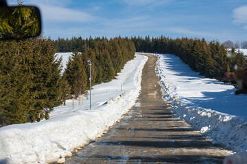Roadtrip durch Rumänien, einsame geräumte Straße im verschneiten Gebirge