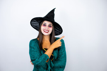 Woman wearing witch costume over isolated white background smiling and pointing with hand and...