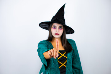 Woman wearing witch costume over isolated white background showing and pointing up with fingers number one while is serious