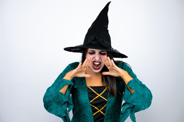 Woman wearing witch costume over isolated white background shouting and screaming loud down with hands on mouth