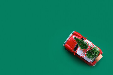 Little red toy car and Christmas tree on a green background © Inna Vlasova