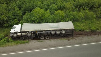 Aerial view of an overturned truck. Car on the side of the highway.