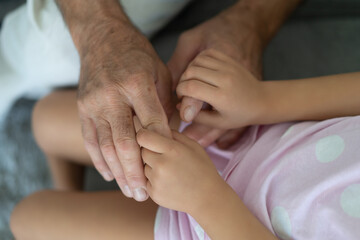 Fototapeta na wymiar hands of a grandfather holding the hands of a girl