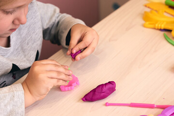 Obraz na płótnie Canvas 3 years girl creative arts. Child hands playing with colorful clay plasticine. Self-isolation Covid-19, online education, homeschooling. Toddler girl studying at home, home learning